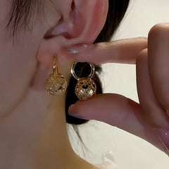 Model showcasing the dangle and style of the 14K Gold-Plated Elegant Zircon Hollow Ball Earrings