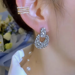 Model showcasing the dangle and style of the 14K Gold-Plated Elegant Zircon Inlaid Geometric Earrings