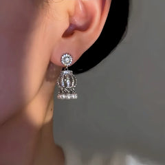 Close-up detail of the sparkling zircons and plating on the silver tassel earrings