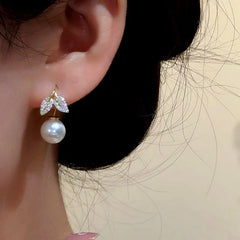 Model showcasing the dangle and style of the 14K Gold-Plated Elegant Zircon Leaf Pearl Ear Hook Earrings