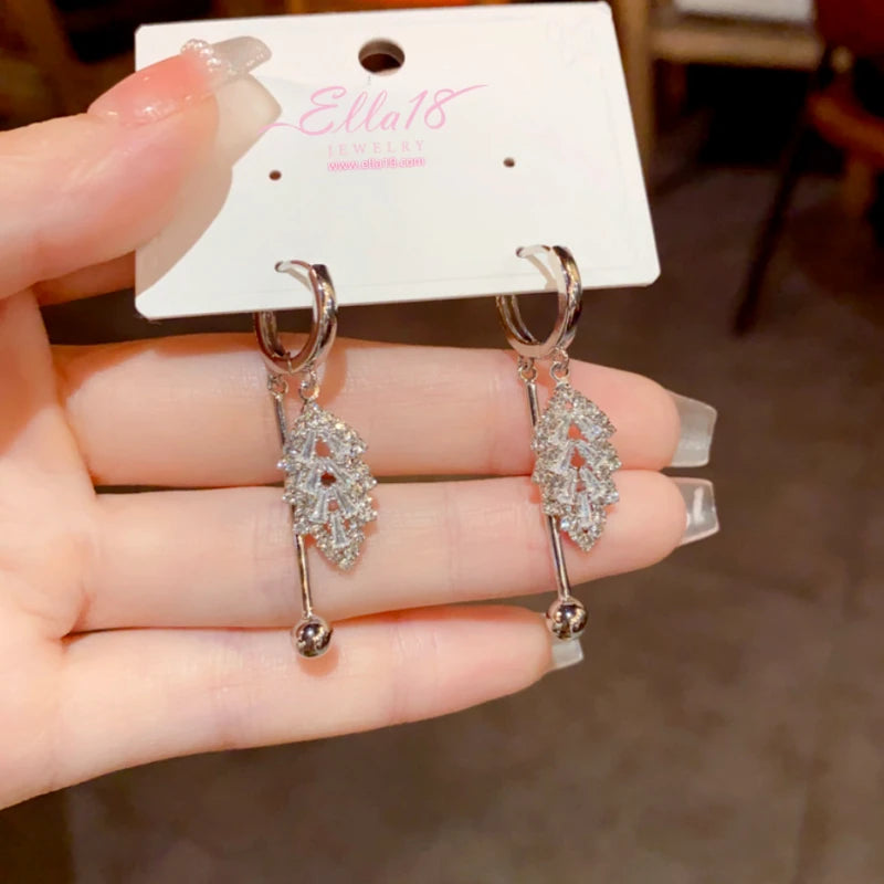 Model showcasing the dangle and style of the 14K Gold-Plated Elegant Zircon Leaf Tassel Earrings