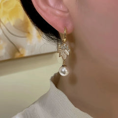 Close-up detail of the sparkling zircons and plating on the gold leaf earrings