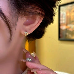 Model showcasing the dangle and style of the 14K Gold-Plated Elegant Zircon Nail Integrated Hoop Earrings
