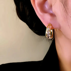 Close-up detail of the sparkling zircons and plating on the gold hoop earrings