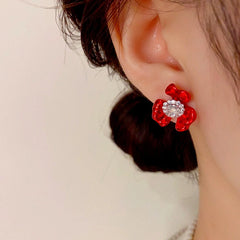 Close-up detail of the sparkling zircons and plating on the red flower earrings