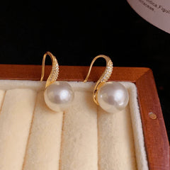Close-up detail of the sparkling zircons and plating on the gold pearl earrings