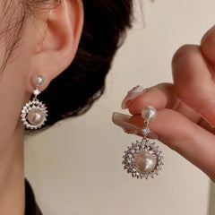 Model showcasing the dangle and style of the 14K Gold-Plated Elegant Zircon Pearl Sunflower Earrings