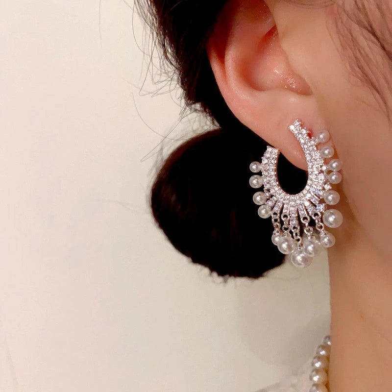 Model showcasing the dangle and style of the 14K Gold-Plated Elegant Zircon Pearl Tassel Earrings