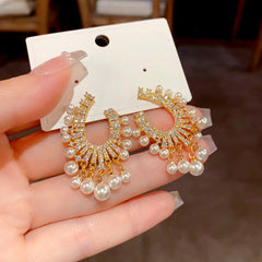 Close-up detail of the sparkling zircons and plating on the gold tassel earrings