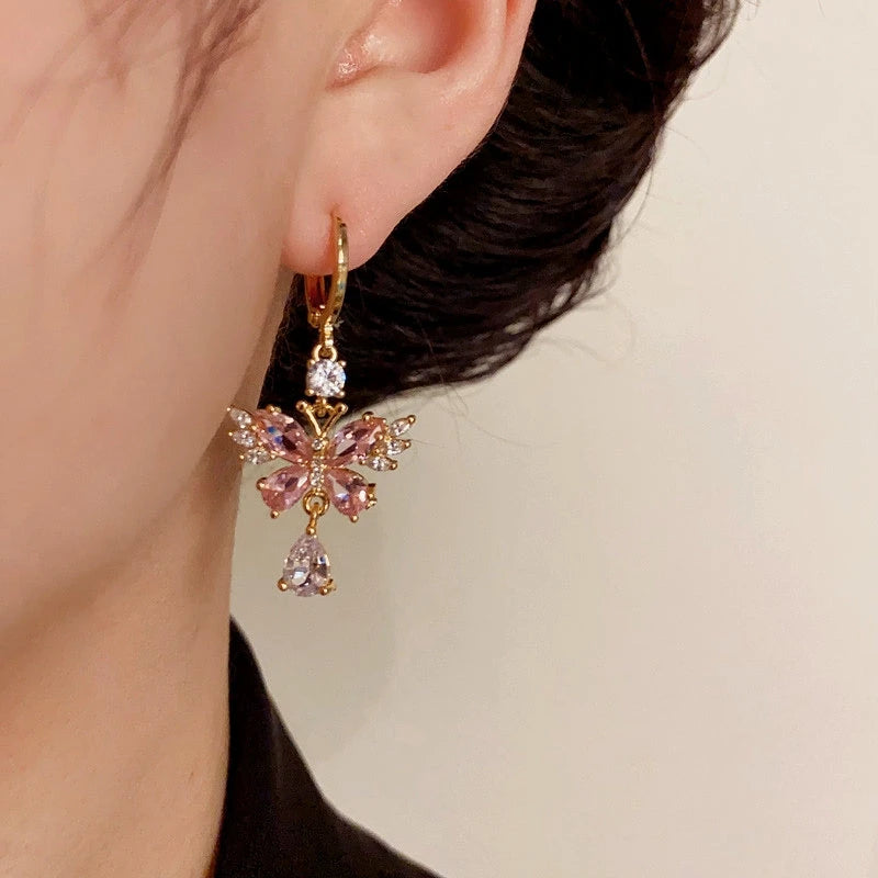 Model showcasing the dangle and style of the 14K Gold-Plated Elegant Zircon Pink Butterfly Water Drop Earrings