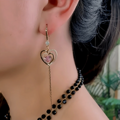 Model showcasing the dangle and style of the 14K Gold-Plated Elegant Zircon Pink Diamond Heart Ear Hook Earrings