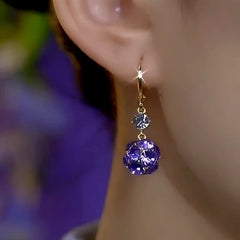 Model showcasing the dangle and style of the 14K Gold-Plated Elegant Zircon Purple Diamond Ball Earrings