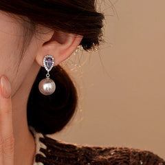 Model showcasing the dangle and style of the 14K Gold-Plated Elegant Zircon Purple Diamond Pearl Earrings