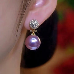 Model showcasing the dangle and style of the 14K Gold-Plated Elegant Zircon Purple Pearl Earrings