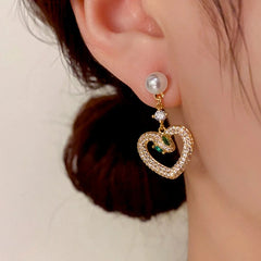 Model showcasing the dangle and style of the 14K Gold-Plated Elegant Zircon Snake-Heart Pearl Earrings