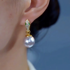 Model showcasing the dangle and style of the 14K Gold-Plated Elegant Zircon Snake White Pearl Earrings