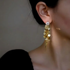 Model showcasing the dangle and style of the 14K Gold-Plated Elegant Zircon Sun Flower Tassel Earrings