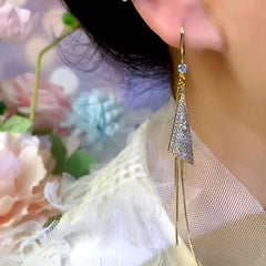 Model showcasing the dangle and style of the 14K Gold-Plated Elegant Zircon Triangle Long Tassel Hook Earrings