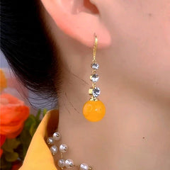 Model showcasing the dangle and style of the 14K Gold-Plated Elegant Zircon Yellow Bead Ear Hooks