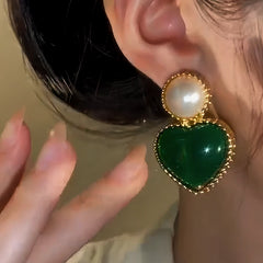Model showcasing the dangle and style of the 14K Gold-Plated Emerald Heart Earrings