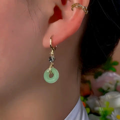 Model showcasing the dangle and style of the 14K Gold-Plated Exquisite Ancient Style Peace Buckle Earrings