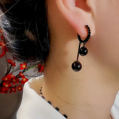 Close-up detail of the sparkling zircons and plating on the Black Ball Pearl Earrings