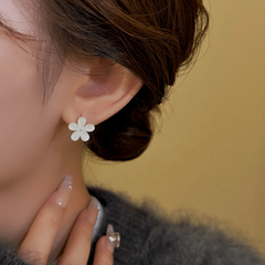 Model showcasing the dangle and style of the 14K Gold-Plated Exquisite Cat's Eye Little Flower Hoop Earrings