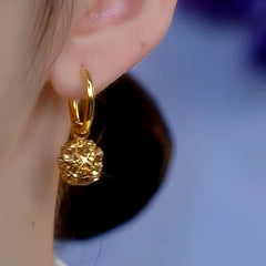 Model showcasing the dangle and style of the 14K Gold-Plated Exquisite Coffee Color Diamond Ball Earrings