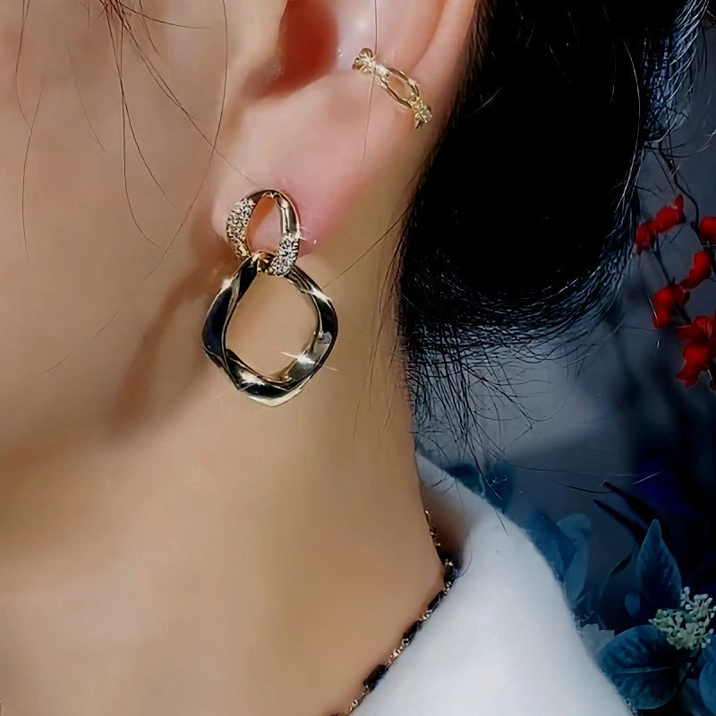 Model showcasing the dangle and style of the 14K Gold-Plated Exquisite Diamond Double-Layer Interlocking Earrings