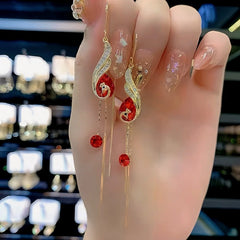 Angled view of the 14K Gold-Plated Exquisite Phoenix Crystal Threader Tassel Earrings