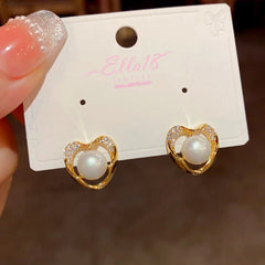 Model showcasing the dangle and style of the 14K Gold-Plated Exquisite Simple Zircon Pearl Heart Stud Earrings