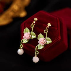 Angled view of the 14K Gold-Plated Flower And Green Leaf Earrings