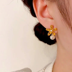 Model showcasing the dangle and style of the 14K Gold-Plated Flower Hanging Pearl Earrings