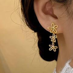 Model showcasing the dangle and style of the 14K Gold-Plated Flower Knot Tassel Earrings