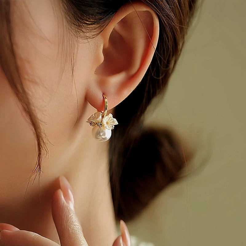 Model showcasing the dangle and style of the 14K Gold-Plated Flower Pearl Earrings
