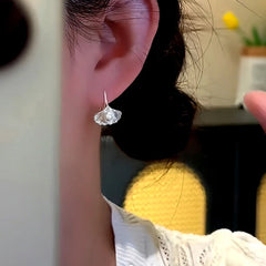 Model showcasing the dangle and style of the 14K Gold-Plated Ginkgo Leaf Ear Hook Earrings