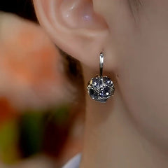 Model showcasing the dangle and style of the 14K Gold-Plated Gray Diamond Ball Earrings