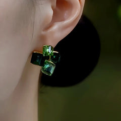 Model showcasing the dangle and style of the 14K Gold-Plated Green Diamond Stud Earrings