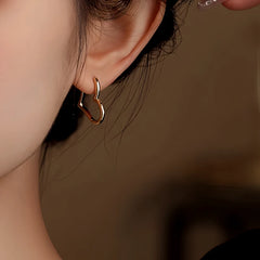 Close-up detail of the sparkling zircons and plating on the Large Heart Earrings