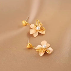 Model showcasing the dangle and style of the 14K Gold-Plated Heart-Design Flower Earrings
