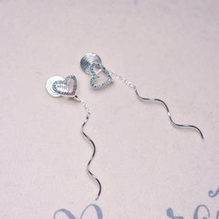 Model showcasing the dangle and style of the 14K Gold-Plated Heart Design Ear Clip Tassel Earrings