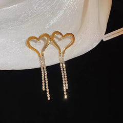 Model showcasing the dangle and style of the 14K Gold-Plated Heart Zircon Tassel Earrings