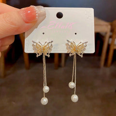 Angled view of the 14K Gold-Plated Hollow Butterfly Pearl Tassel Earrings