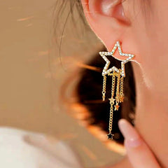 Model showcasing the dangle and style of the 14K Gold-Plated Hollow Five-Pointed Star Tassel Earrings
