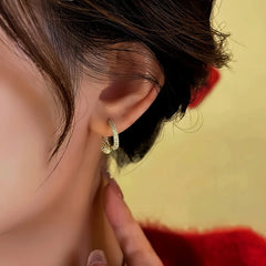 Model showcasing the dangle and style of the 14K Gold-Plated Interlaced Snake Head And Tail Earrings