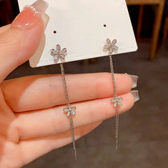 Angled view of the 14K Gold-Plated Long Diamond Flower Tassel Earrings