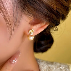 Model showcasing the dangle and style of the 14K Gold-Plated Lucky Bag Pearl Earrings