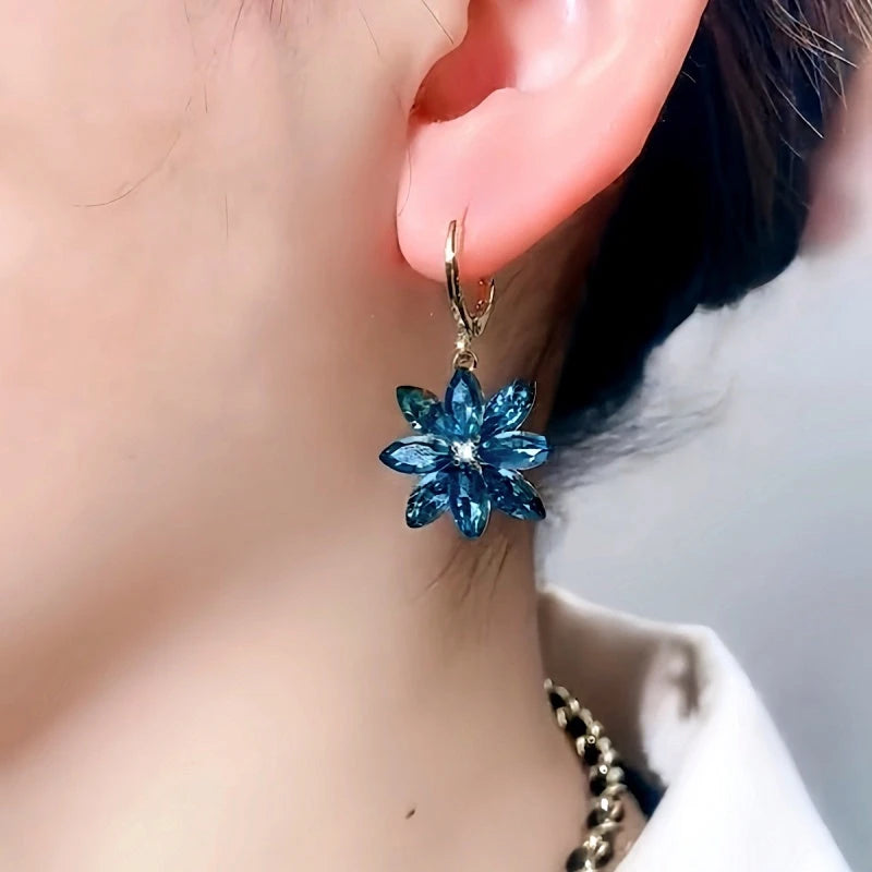 Model showcasing the dangle and style of the 14K Gold-Plated Luxury Blue Crystal Flower Earrings