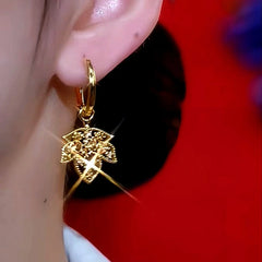 Model showcasing the dangle and style of the 14K Gold-Plated Luxury Brown Diamond Leaf Earrings