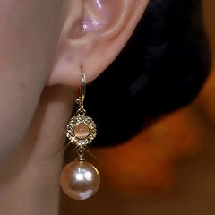 Model showcasing the dangle and style of the 14K Gold-Plated Luxury Brown Zircon Cat's Eye Pearl Earrings